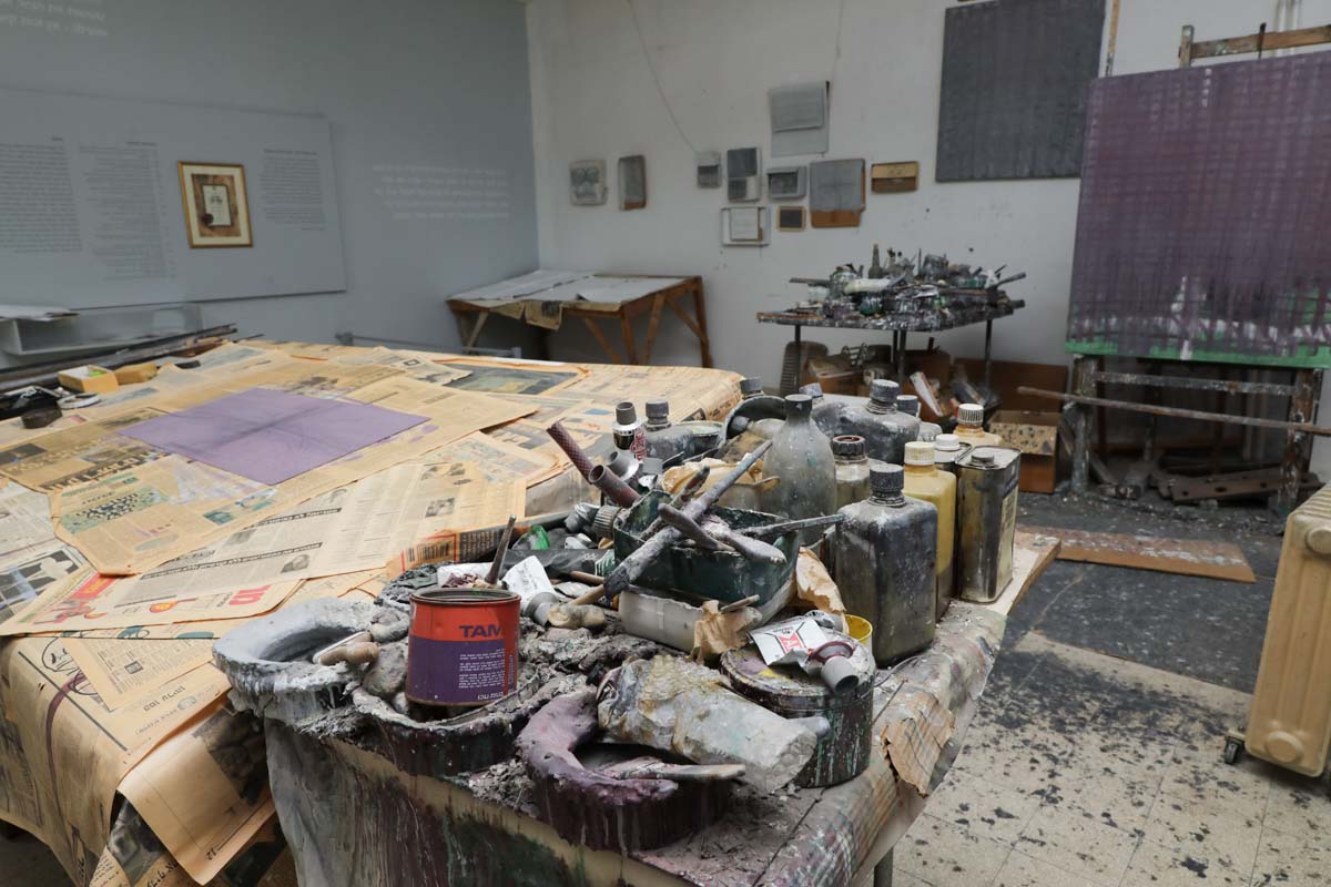 שולחן עבודה והמון מברשות, מכחולים, כלים שונים וצבעים בתערוכת אוסף קופפרמן.